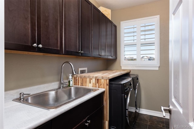 laundry area with independent washer and dryer, a sink, cabinet space, and baseboards