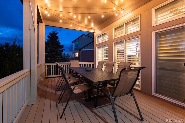 deck at twilight with outdoor dining area