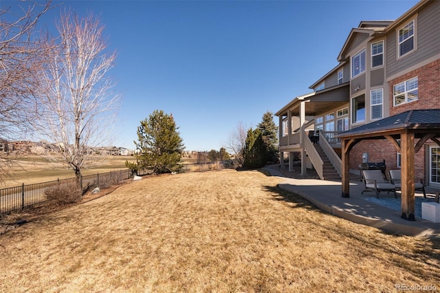 view of yard with stairs, a patio, and fence