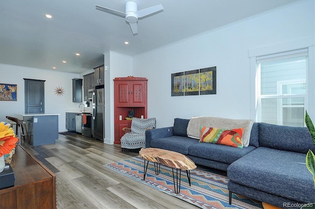 living room featuring ceiling fan, dark hardwood / wood-style flooring, sink, and ornamental molding