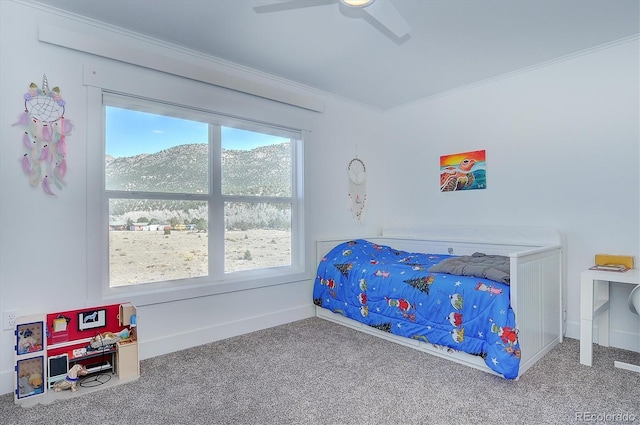 bedroom featuring carpet, ceiling fan, a mountain view, and crown molding