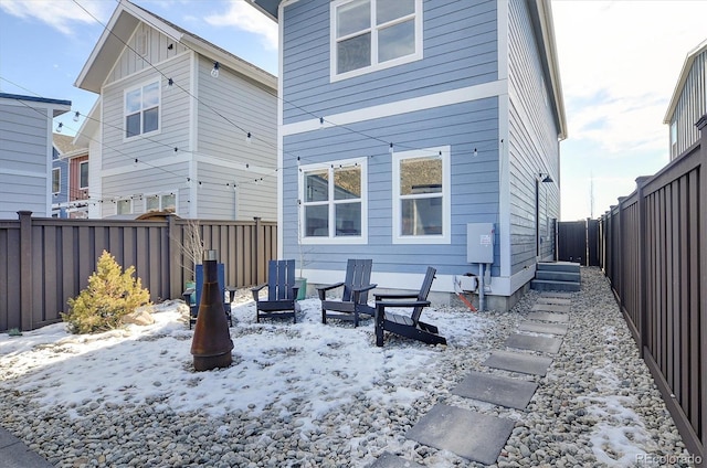 view of snow covered rear of property