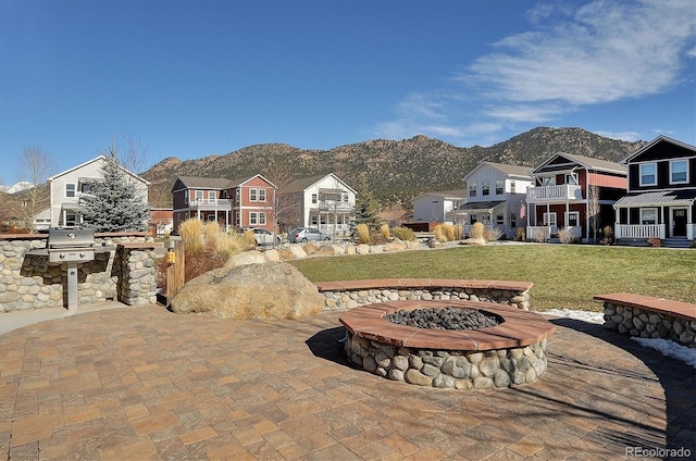 exterior space featuring a mountain view, a balcony, and an outdoor fire pit