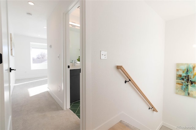 hallway featuring light carpet and sink