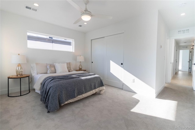 bedroom with light colored carpet, a closet, and ceiling fan