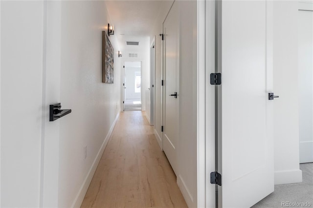 corridor with light hardwood / wood-style floors