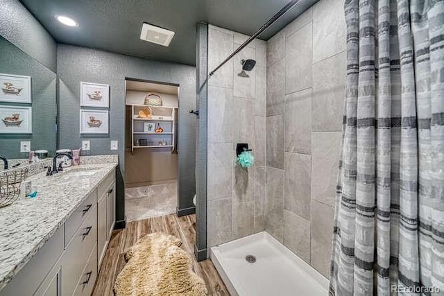 336 Arrowhead Dr, Florence, CO 81226 - bathroom with wood finished floors, vanity, and tiled shower