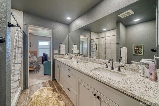 336 Arrowhead Dr, Florence, CO 81226 - ensuite bathroom with wood finished floors, double vanity, a stall shower, and a textured wall