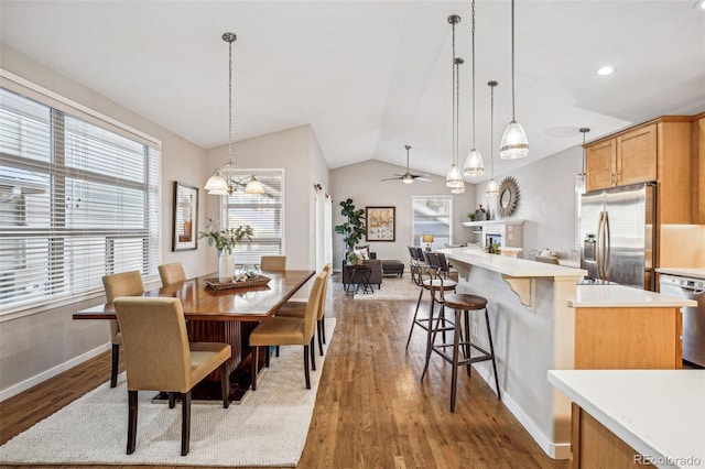 dining space featuring hardwood / wood-style floors, ceiling fan, and vaulted ceiling