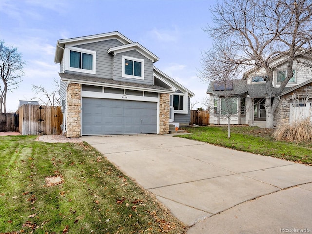 view of front of house with stone siding, fence, concrete driveway, and a front yard