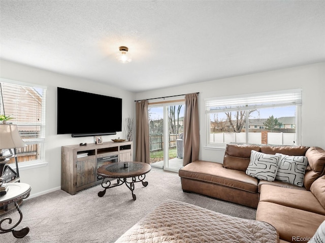 living room featuring carpet floors, a textured ceiling, and baseboards