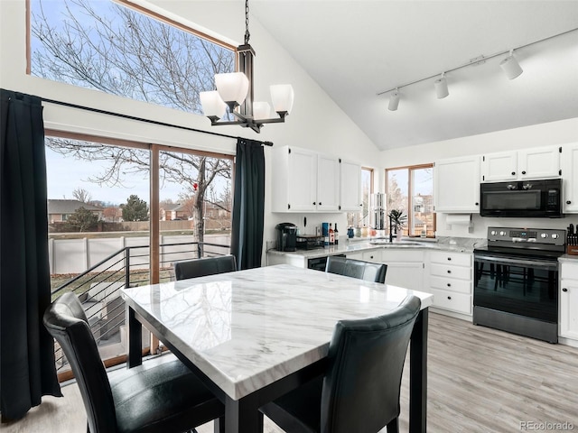 kitchen with black microwave, a chandelier, white cabinets, light wood-type flooring, and stainless steel electric stove