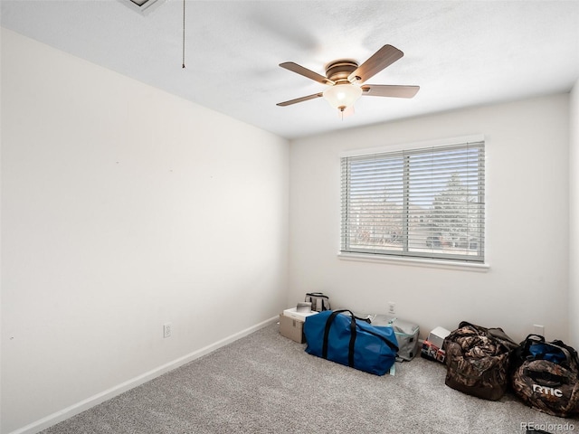 interior space with attic access, carpet, baseboards, and a ceiling fan