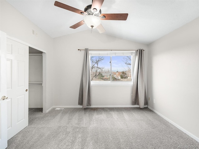 unfurnished bedroom with lofted ceiling, carpet, baseboards, and a closet