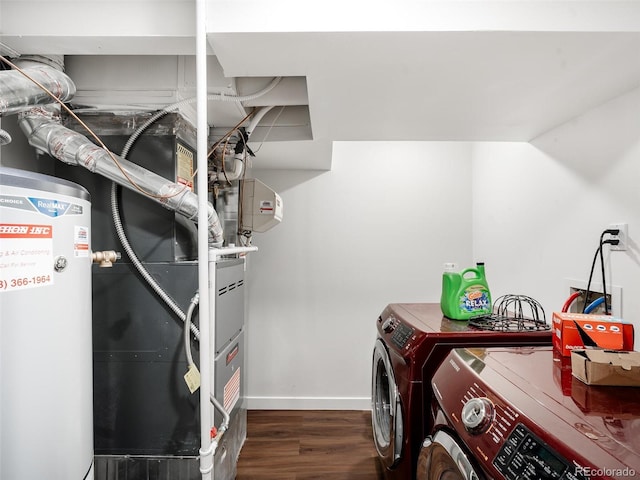 clothes washing area with laundry area, baseboards, wood finished floors, washing machine and dryer, and water heater