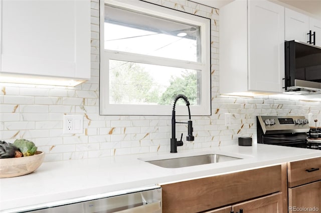 1617 S Quitman St, Denver, CO 80219 - kitchen featuring a sink, appliances with stainless steel finishes, backsplash, light countertops, and white cabinetry