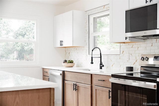 1617 S Quitman St, Denver, CO 80219 - kitchen featuring stainless steel appliances, a sink, decorative backsplash, and light countertops