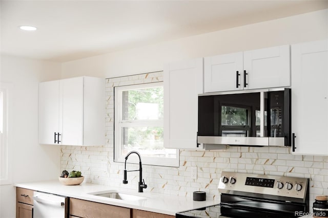 1617 S Quitman St, Denver, CO 80219 - kitchen featuring stainless steel range with electric cooktop, dishwasher, a sink, light countertops, and decorative backsplash