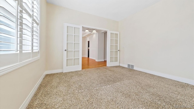 carpeted empty room featuring french doors