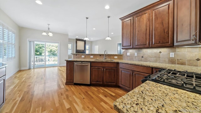 kitchen featuring sink, dishwasher, light stone counters, decorative backsplash, and decorative light fixtures