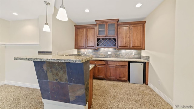 bar featuring light carpet, pendant lighting, stainless steel refrigerator, and decorative backsplash