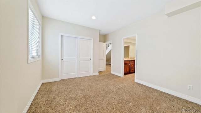 unfurnished bedroom featuring light colored carpet and a closet