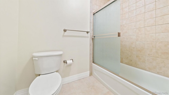 bathroom featuring tile patterned flooring, enclosed tub / shower combo, and toilet