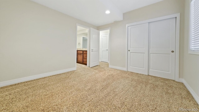 unfurnished bedroom featuring light carpet and a closet