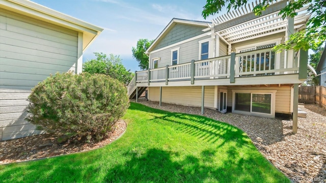 rear view of property featuring a wooden deck and a yard