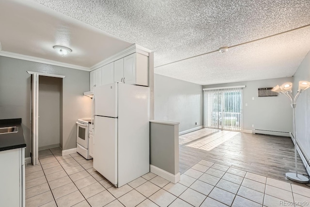 kitchen featuring white appliances, light tile patterned floors, white cabinets, and a textured ceiling