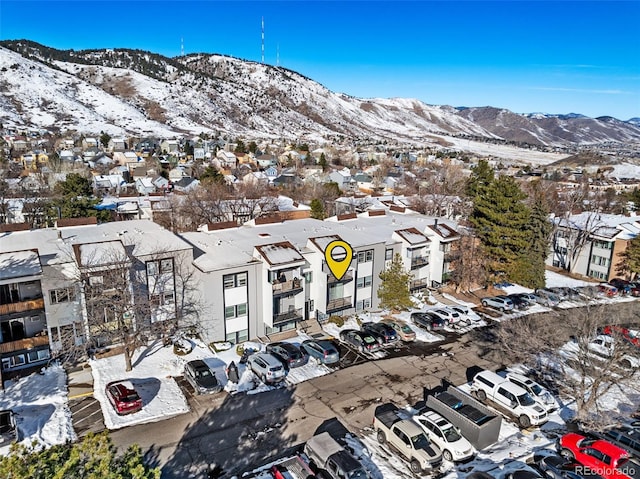 snowy aerial view featuring a residential view and a mountain view