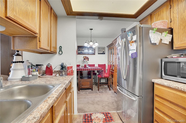 kitchen featuring appliances with stainless steel finishes, sink, decorative light fixtures, light colored carpet, and an inviting chandelier