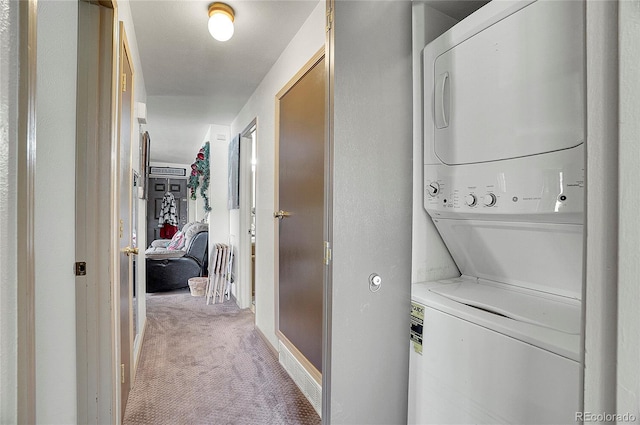 laundry area with stacked washer / dryer and carpet flooring