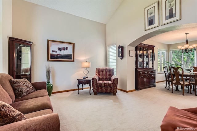 9791 Sterling Dr, Highlands Ranch, CO 80126 - living room with arched walkways, a chandelier, light colored carpet, and high vaulted ceiling