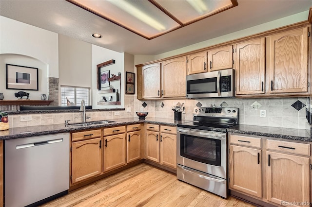 9791 Sterling Dr, Highlands Ranch, CO 80126 - kitchen with stainless steel appliances, dark stone countertops, light wood-type flooring, backsplash, and recessed lighting