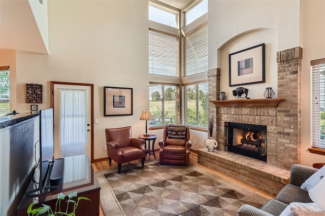 9791 Sterling Dr, Highlands Ranch, CO 80126 - living room featuring wood finished floors, a fireplace, a high ceiling, and healthy amount of natural light