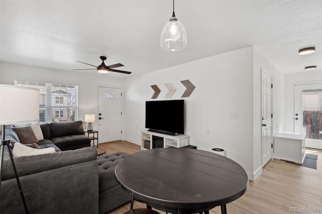 7654 Crestone Peak Trl, Colorado Springs, CO 80924 - living room with healthy amount of natural light, light wood finished floors, ceiling fan, and baseboards