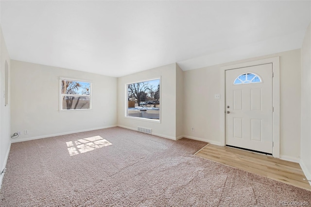 entrance foyer featuring carpet, visible vents, and baseboards