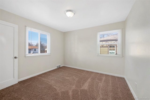 carpeted spare room with baseboards and visible vents