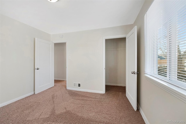 unfurnished bedroom featuring carpet flooring, visible vents, and baseboards