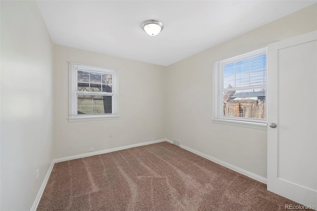 carpeted empty room featuring baseboards