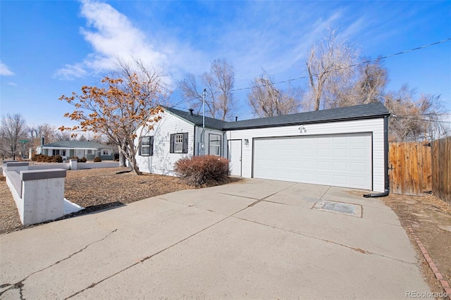 ranch-style home featuring driveway, a garage, and fence