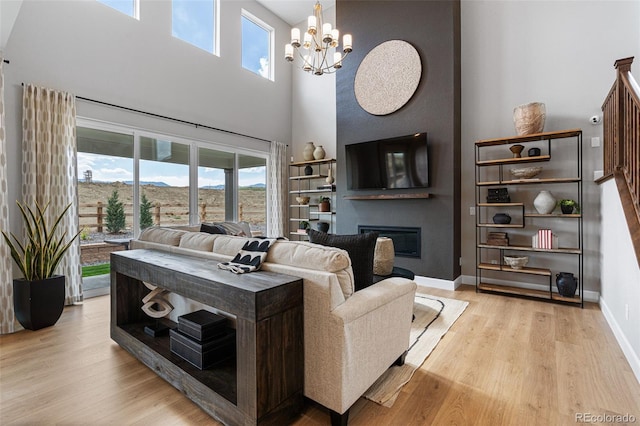 living room with a notable chandelier, light hardwood / wood-style flooring, and a wealth of natural light