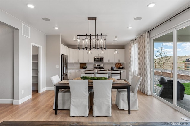 dining room featuring an inviting chandelier and light hardwood / wood-style flooring