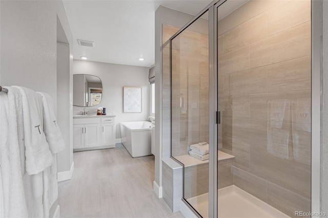 bathroom with vanity and independent shower and bath