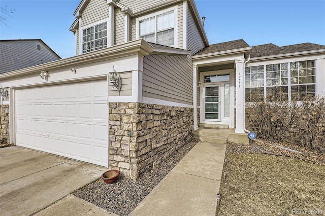 view of front facade with stone siding and a garage