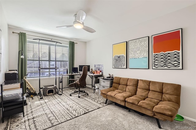 carpeted office space with baseboards and ceiling fan