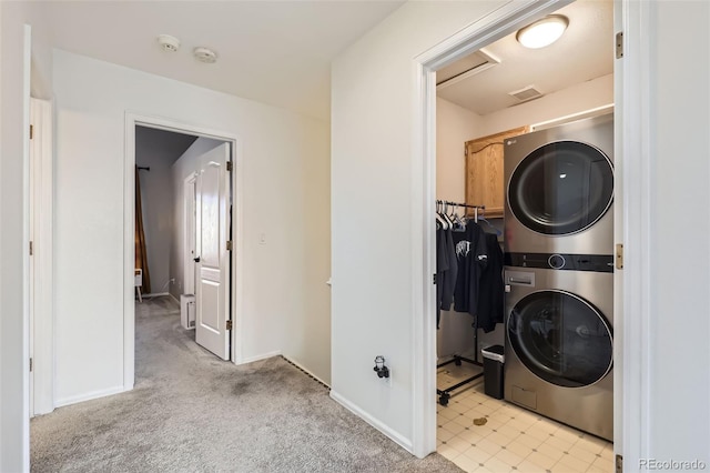 clothes washing area featuring visible vents, stacked washer / drying machine, baseboards, attic access, and laundry area