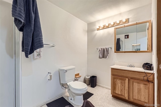 bathroom featuring toilet, vanity, and baseboards