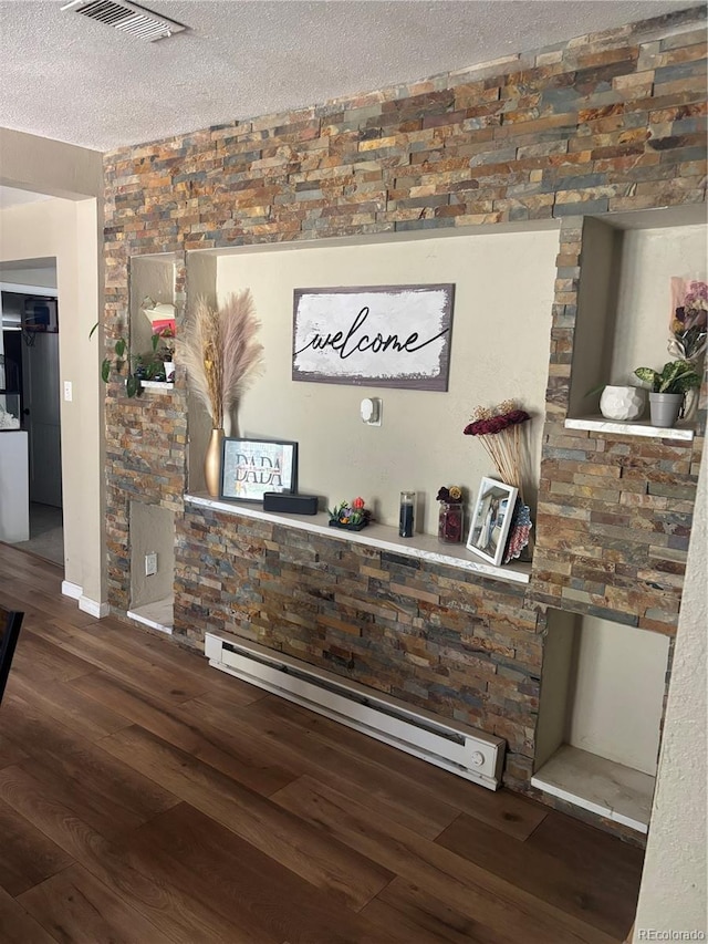 206 Lyell St, Monte Vista, CO 81144 - detailed view of a baseboard heating unit, a textured ceiling, and wood finished floors